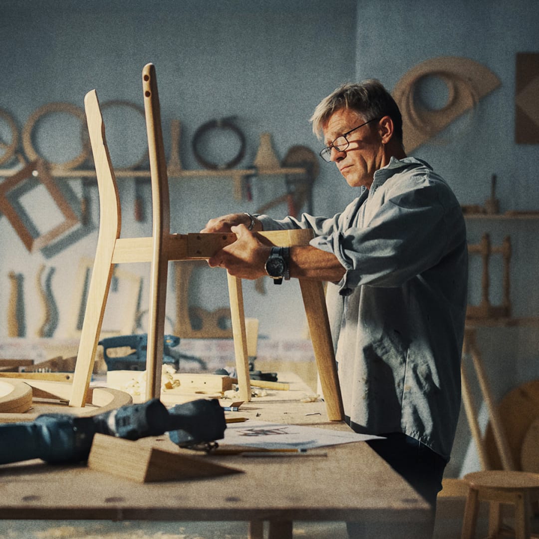 Man finishing a chair in a warehouse